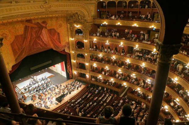 The Argus: A grand theatre with people watching an orchestra. Credit: Canva