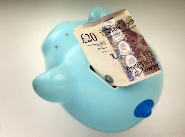 The Argus: Piggy bank with a £20 note. Credit: PA