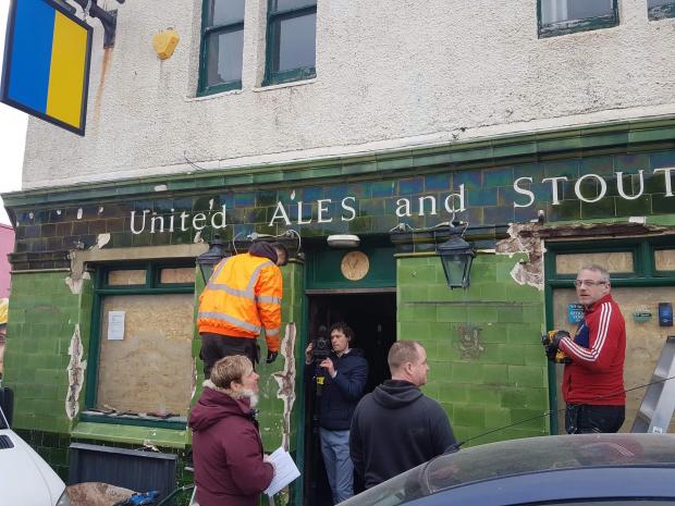The Argus: Workers hack tiles off the Montreal Arms in Brighton 
