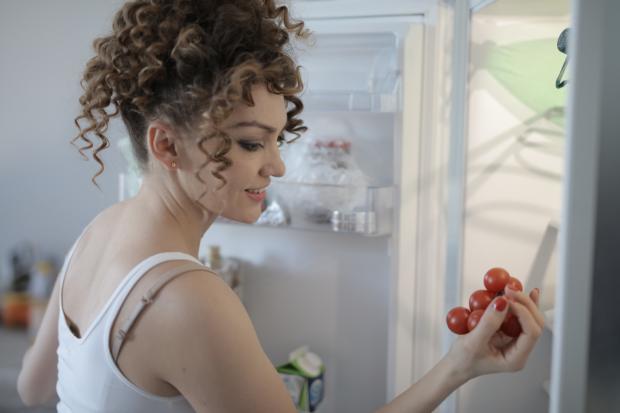 The Argus: A woman putting tomatoes in her fridge. Credit: Canva