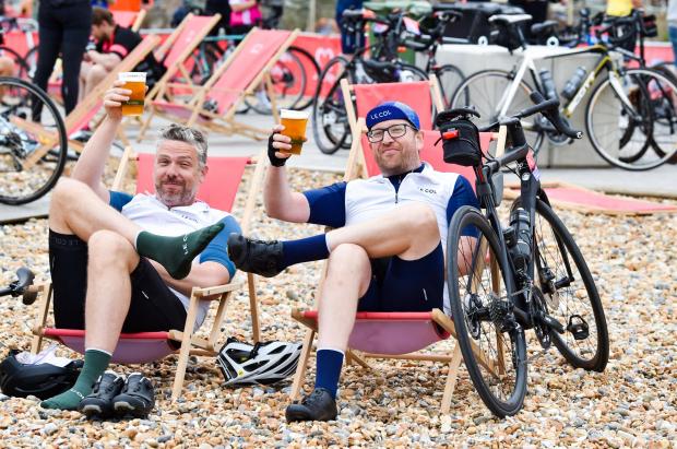 The Argus: Two bikers enjoying a well-deserved sit down on the beach after the ride