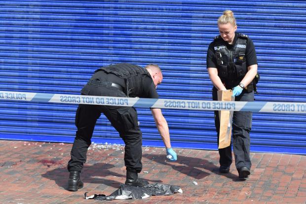 The Argus: Police clearing the scene the next day. Blood can be seen on the floor