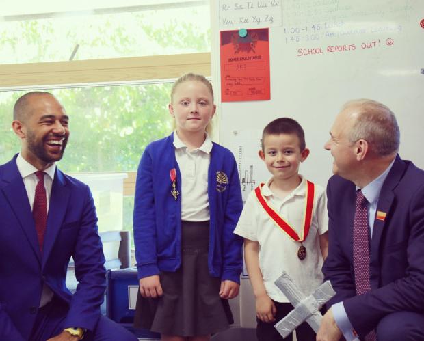 The Argus: Sir Ed Davey and Josh Babarinde OBE present their medals to two students at Shinewater Primary School