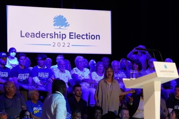 The Argus: A protester interrupts Liz Truss's speech during a hustings event in Eastbourne