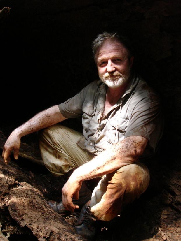 The Argus: Entomologist and television presenter George McGavin, in hollowed out-log in Borneo.  Picture by Tim Martin