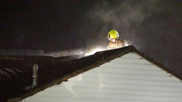 The Argus: A firefighter on the roof of a property in Littlehampton after it was struck by lightning last night