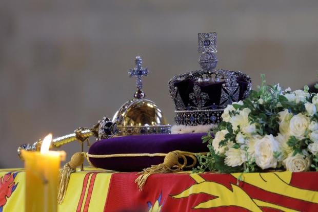 The Argus: The royal standard with the imperial state crown and the orb and scepter of the sovereign rest on the Queen's coffin with her while she lies in state (Marko Djurica/PA)