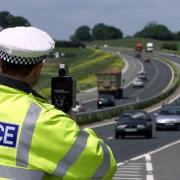The woman was caught speeding by police. A stock image of a policeman using a speed gun