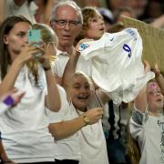 A young England fan smiles after receiving the match shirt from Ellen White after the Lionesses' victory at the Amex