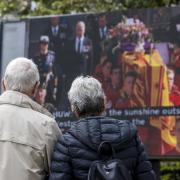 People in the grounds of Belfast City Hall watch Queen Elizabeth's funeral