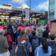 Protesters outside Brighton station held banners and signs before marching through the city