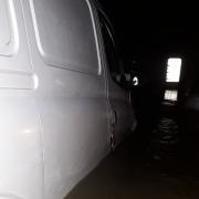 A van and car were seen stranded in deep floodwater along the road in Barcombe