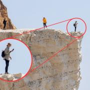 The woman is right at the cliff edge