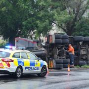 A cement lorry has overturned on a roundabout