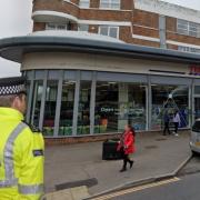 A police officer super-imposed on a photo of Tesco Express, Seaford