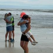 Two adventurers have completed their run across the US. Pictured is Jan Dupree hugging her granddaughter Nola and Kurt Charnock hugging his partner Jody at the finish line