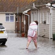 A person walking through floodwater in Littlehampton