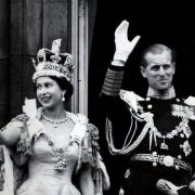 Queen Elizabeth II wearing the Imperial State Crown and the Duke of Edinburgh in uniform of Admiral of the Fleet waving from the balcony to the onlooking crowds around the gates of Buckingham Palace after the Coronation