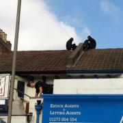 STANDOFF: Police and squatters on the roof prior to the raid