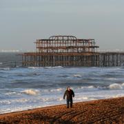 People walking near the West Pier on Brighton seafront as storms batter the coast.  Picture: Simon Dack.