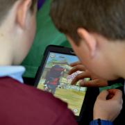 Youngsters use an iPad in a classroom