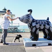 A dogwalker meets Flower the Snowdog decorated by artist Kai and Sunny and sponsored by Mackley Construction by Brighton bandstand on Friday morning.