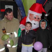 Henfield fire service watch commander Paul Smith with James Melville and George Dean, both 4, outside Santa's grotto in Henfield