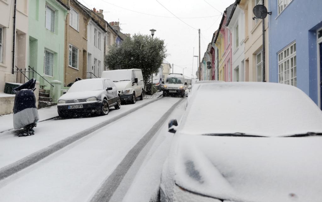 Traffic carefully negotiates the steep streets of the Hanover area in Brighton as snow falls this morning