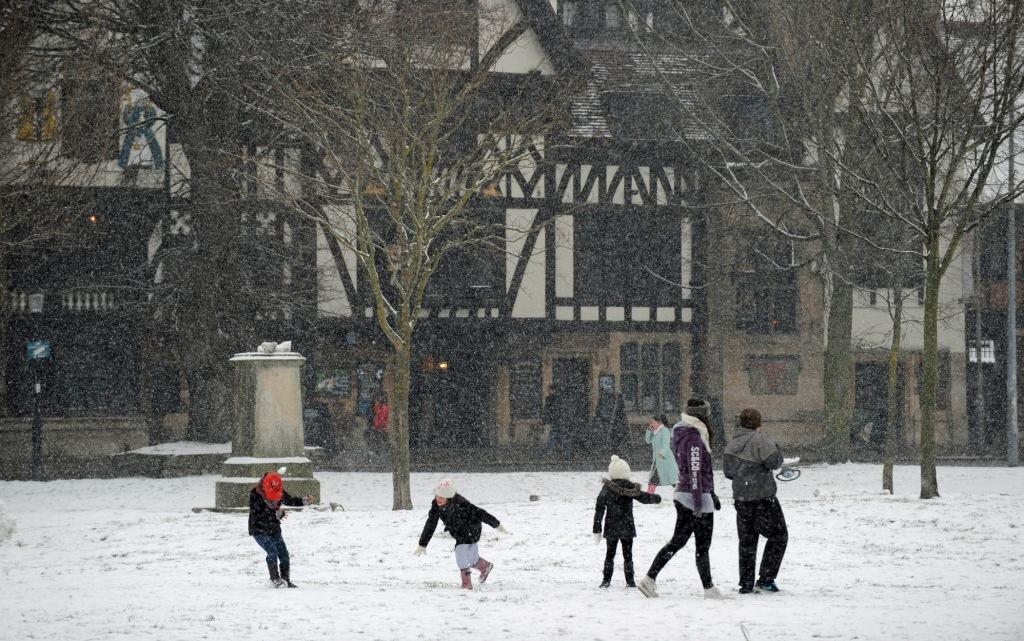 A family enjoys a snowball fight in Victoria Gardens Brighton 