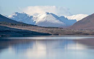 The snow-covered peak of Beinn Eighe and the mountains of Torridon are reflected in Loch Glascarnoch near Ullapool, Wester Ross. (Jane Barlow/PA)
