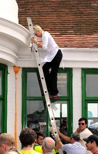 Heather Mills climbs a ladder up to the roof of her new cafe VBites
